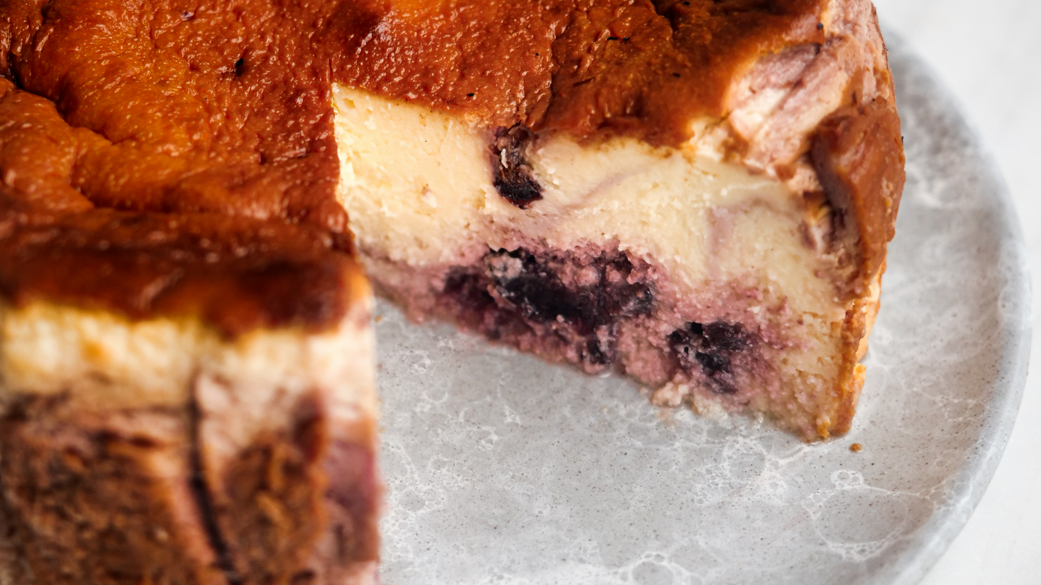 Basque cheesecake with a slice cut out of it recipe poster image