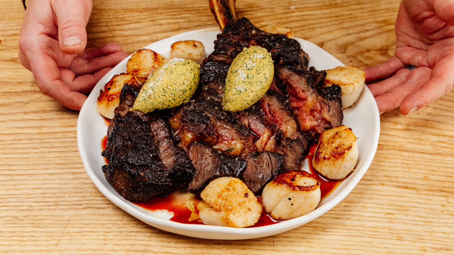 Steak and scallops with compound butter on a plate recipe poster image